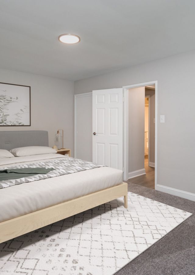 Minimalist bedroom with a large bed, gray walls, two nightstands, and simple wall art above the bed.