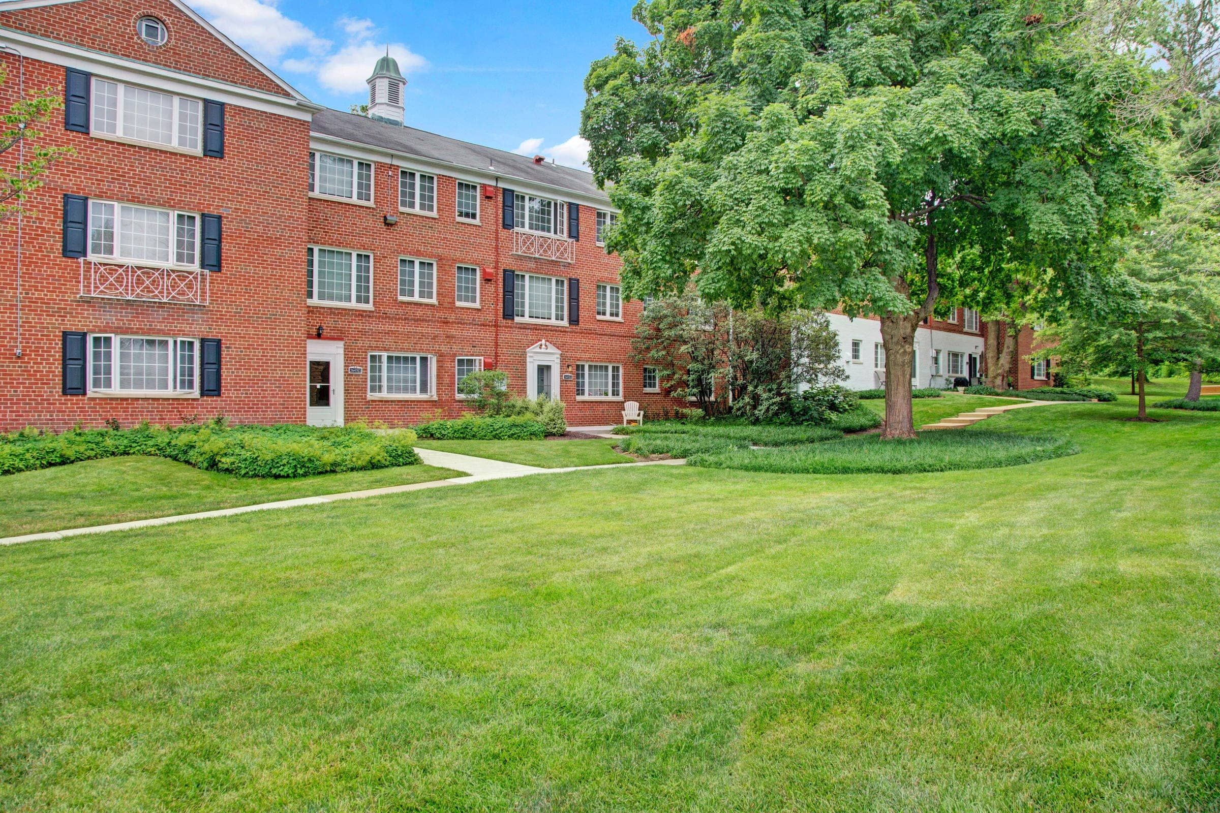 A building with a lawn and trees.